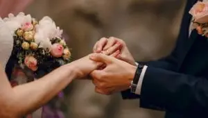 Noivos trocando alianças de casamento, ilustrando os diferentes regimes de bens do casamento civil e a nacionalidade portuguesa por casamento.