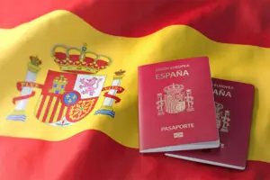 Passaportes espanhóis da União Europeia sobre a bandeira da Espanha, ilustrando a nacionalidade espanhola por residência para brasileiros.